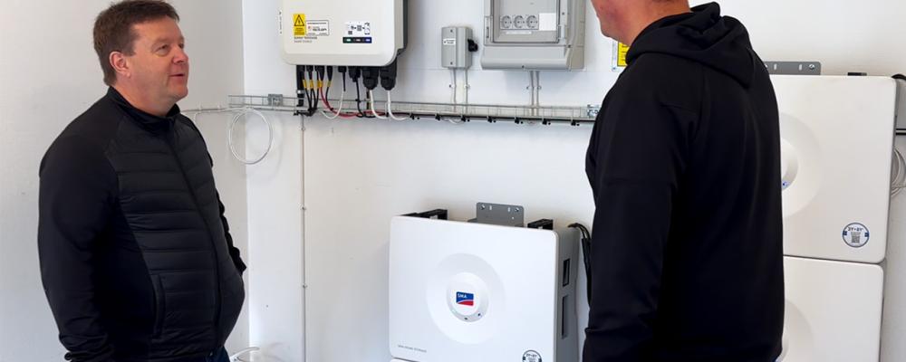 I denna batteriinstallation används fem SMA Home Storage-batterier med en sammanlagd kapacitet på 16,4 kWh. Systemet är utrustat med smart styrning och backupfunktion som gör det möjligt att lagra solel för egen användning och samtidigt ha tillgång till ström vid eventuella elavbrott. På bilden diskuteras anläggningens drift och övervakning, som bidrar till effektiv energianvändning och ökad självförsörjning. Foto: I denna batteriinstallation används fem SMA Home Storage-batterier med en sammanlagd kapacitet på 16,4 kWh. Systemet är utrustat med smart styrning och backupfunktion som gör det möjligt att lagra solel för egen användning och samtidigt ha tillgång till ström vid eventuella elavbrott. På bilden diskuteras anläggningens drift och övervakning, som bidrar till effektiv energianvändning och ökad självförsörjning. Av: Anna-Karin Jeppsson