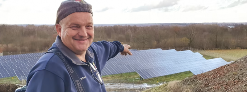 Mose Freyer på Moses Bil&Lack i Tollarp pekar ut över sin solpark - "Jag är gudaglad att jag investerade i det här, nu är drömmen att bygga dubbelt så stort". Foto: EnergiEngagemang