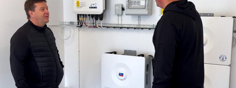 I denna batteriinstallation används fem SMA Home Storage-batterier med en sammanlagd kapacitet på 16,4 kWh. Systemet är utrustat med smart styrning och backupfunktion som gör det möjligt att lagra solel för egen användning och samtidigt ha tillgång till ström vid eventuella elavbrott. På bilden diskuteras anläggningens drift och övervakning, som bidrar till effektiv energianvändning och ökad självförsörjning. Foto: I denna batteriinstallation används fem SMA Home Storage-batterier med en sammanlagd kapacitet på 16,4 kWh. Systemet är utrustat med smart styrning och backupfunktion som gör det möjligt att lagra solel för egen användning och samtidigt ha tillgång till ström vid eventuella elavbrott. På bilden diskuteras anläggningens drift och övervakning, som bidrar till effektiv energianvändning och ökad självförsörjning. Av: Anna-Karin Jeppsson