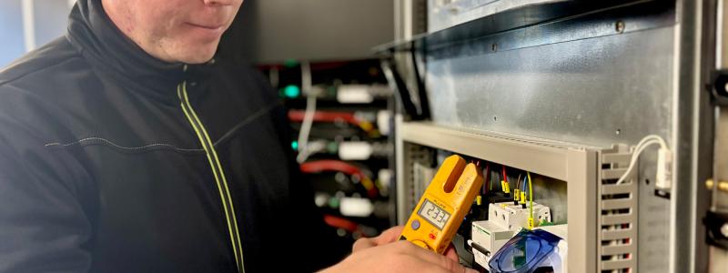 Tobias Andersson kontrollerar eluttaget som är kopplat till batteriet. Av: Anna-Karin Jeppsson Upphovsrätt: Nordic Solar