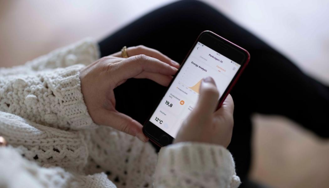 Kvinna med mobil i handen. Foto: C4 Energi