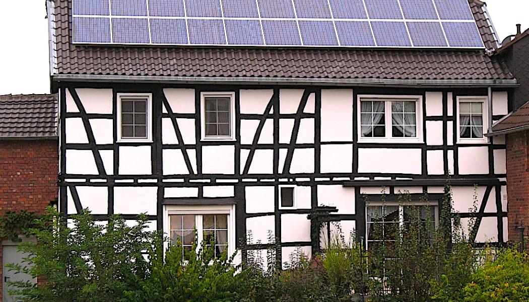 Ett litet takmonterat solcellssystem i ett gammalt korsvirkes trähus i Buschhoven nära Bonn, Tyskland. Foto: kredit: Túrelio (via Wikimedia-Commons),