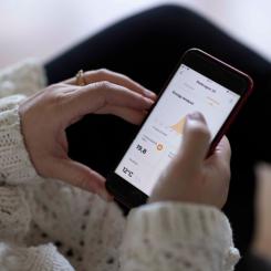 Kvinna med mobil i handen. Foto: C4 Energi