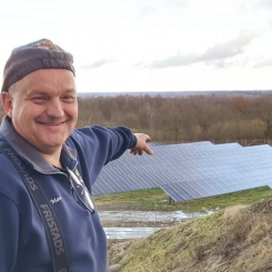 Mose Freyer på Moses Bil&Lack i Tollarp pekar ut över sin solpark - "Jag är gudaglad att jag investerade i det här, nu är drömmen att bygga dubbelt så stort". Foto: EnergiEngagemang