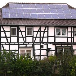 Ett litet takmonterat solcellssystem i ett gammalt korsvirkes trähus i Buschhoven nära Bonn, Tyskland. Foto: kredit: Túrelio (via Wikimedia-Commons),