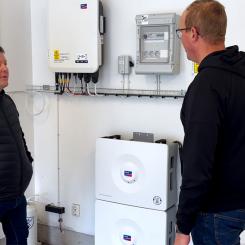 I denna batteriinstallation används fem SMA Home Storage-batterier med en sammanlagd kapacitet på 16,4 kWh. Systemet är utrustat med smart styrning och backupfunktion som gör det möjligt att lagra solel för egen användning och samtidigt ha tillgång till ström vid eventuella elavbrott. På bilden diskuteras anläggningens drift och övervakning, som bidrar till effektiv energianvändning och ökad självförsörjning. Foto: I denna batteriinstallation används fem SMA Home Storage-batterier med en sammanlagd kapacitet på 16,4 kWh. Systemet är utrustat med smart styrning och backupfunktion som gör det möjligt att lagra solel för egen användning och samtidigt ha tillgång till ström vid eventuella elavbrott. På bilden diskuteras anläggningens drift och övervakning, som bidrar till effektiv energianvändning och ökad självförsörjning. Av: Anna-Karin Jeppsson