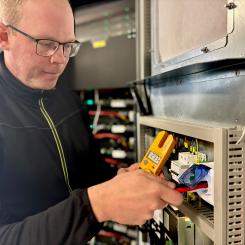 Tobias Andersson kontrollerar eluttaget som är kopplat till batteriet. Av: Anna-Karin Jeppsson Upphovsrätt: Nordic Solar